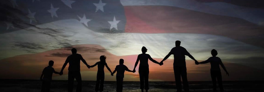 Silhouette of family holding hands in front of an American flag